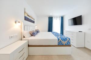 贝尼多姆Sonrisa Deluxe Apartments, Levante的一间白色卧室,配有床和电视