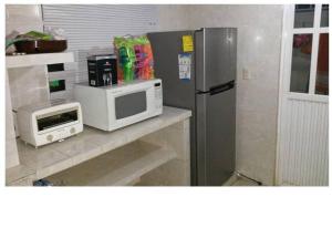 La SabanaCasa en la zona de Acapulco diamante的厨房配有微波炉和冰箱。