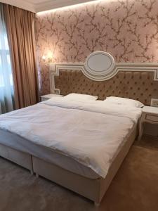雅西Cardinale Resort的一间卧室配有一张大床,墙上设有一面镜子