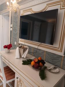 雅西Cardinale Resort的一张桌子,上面放着一台电视和一碗水果