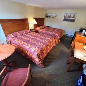 巴特利特北美殖民地汽车旅馆和小屋的酒店客房设有两张床和一张桌子。