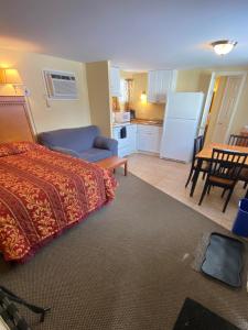 巴特利特北美殖民地汽车旅馆和小屋的一间卧室配有一张床铺和一张桌子,还设有一间厨房