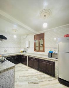 阿加迪尔darna surf house anza的厨房配有白色冰箱和木制橱柜。