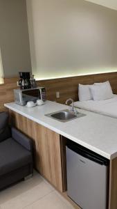 新拉雷多HOTEL LOS ROBLES的一个带水槽的厨房和一张位于客房内的床