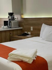 新拉雷多HOTEL LOS ROBLES的酒店客房配有两张床和微波炉。