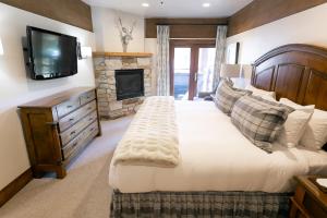 帕克城鹿谷斯坦埃里克森旅舍的一间卧室设有一张大床和一个壁炉