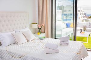 菲内斯特拉特Seascape Apartamento的卧室配有白色床和毛巾