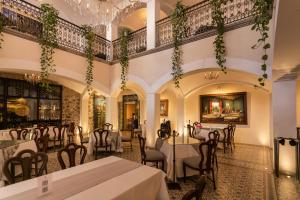 普埃布拉玛丽亚卡索纳酒店的一间带桌椅和吊灯的餐厅