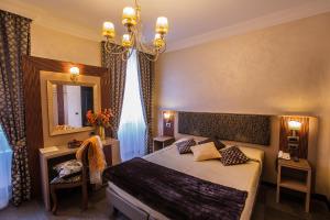 罗马罗马诺酒店的一间卧室配有一张床、镜子和吊灯