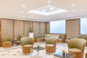迪拜Golden Sands Suites的一间设有桌椅的酒店等候室