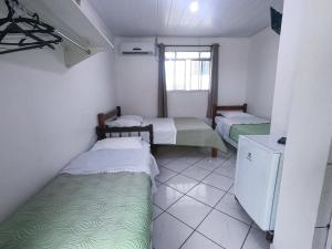 巴拉那州蓬塔尔HOTEL MORADA DO SOL的小房间设有两张床和窗户