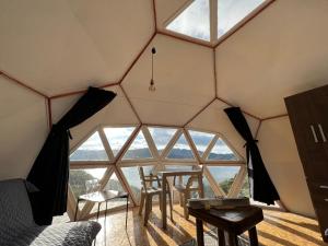 瓜塔维塔Glamping Vista Lago Guatavita的帐篷内的房间,配有桌椅