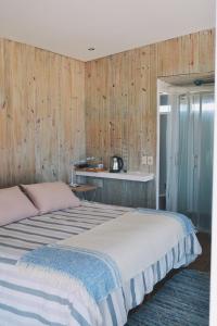 德尔迪阿布罗角Remanso del Diablo的一间卧室设有两张床和木墙