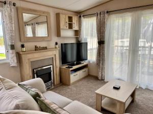 尚克林3 Bedroom Caravan MC34, Lower Hyde, Shanklin, Isle of Wight的一间带电视和壁炉的客厅