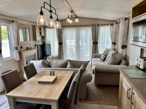 尚克林3 Bedroom Caravan MC34, Lower Hyde, Shanklin, Isle of Wight的客厅配有沙发和桌子
