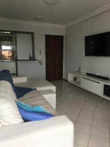 马蒂尼奥斯Lindo apartamento com vista para o mar的客厅配有白色沙发和平面电视。