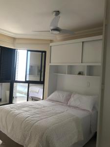 马蒂尼奥斯Lindo apartamento com vista para o mar的一间卧室配有一张带白色床头板的床