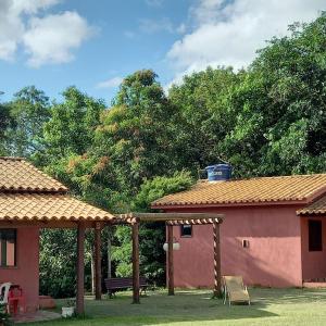瓦尔任博尼塔Pousada Recanto do Sossego- Serra da Canastra的庭院中设有凉亭和长凳的房子