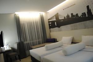 万隆维奥韦斯特霍夫酒店的酒店客房,设有两张床和一张沙发