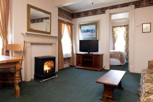 汤森港The Bishop Hotel的客厅设有壁炉和电视。