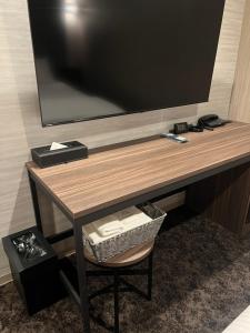 大阪HOTEL GrayⅡ的一张桌子,墙上有一台电视,椅子