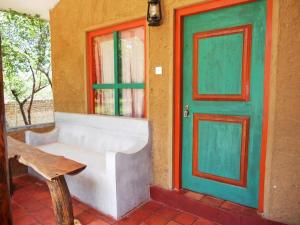 波隆纳鲁沃克雷哈特村住宿加早餐旅馆的一间设有门、长凳和窗户的房间