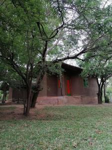 波隆纳鲁沃克雷哈特村住宿加早餐旅馆的一座有红门和一些树木的房子