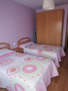 阿尔玛桑Apartamento El Prado的配有粉红色和白色毯子的客房内的两张床