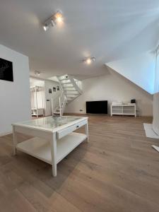 杜伊斯堡Ruhrgebiet-Apartments in Duisburg Stadtmitte的客厅设有白色桌子和楼梯。