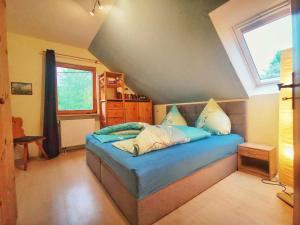 SteinigtwolmsdorfFerienwohnung Gisela的一间卧室配有一张带蓝色床单的床和一扇窗户。