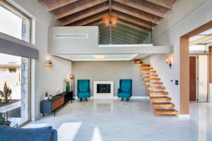 帕莱罗斯Villas Mandalos的一间带楼梯和蓝色椅子的客厅