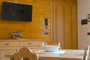 圣斯泰法诺达韦托Residence Grand Hotel SIVA - Adults Only的木墙上的餐桌和电视机