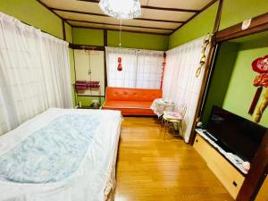 Fuchisaki旅馆yo ko的一间卧室配有一张床、一张沙发和一台电视。
