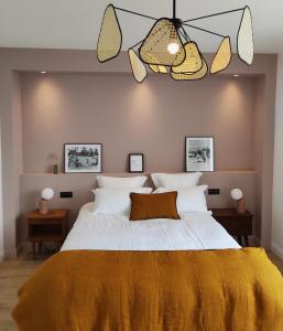 瓦讷Appart hôtel & Spa La Villa du Port的一间卧室配有一张带黄色毯子的大床