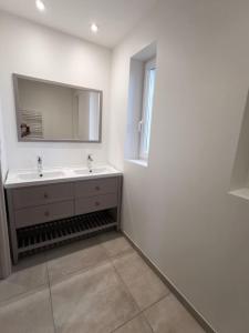 蒙索莱米讷10 rue Carnot的白色的浴室设有水槽和镜子