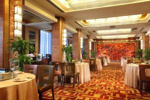 北京民族饭店的用餐室配有桌椅和壁画