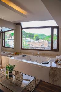 Gokcedere黑鸟Spa酒店的大型浴室设有大浴缸和大窗户