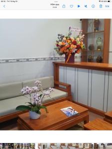 归仁Abalone House Quy Nhơn的客厅配有沙发和鲜花桌