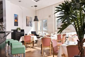 德绍德绍戴斯酒店的一间设有桌椅的餐厅,以及一间种植了植物的餐厅
