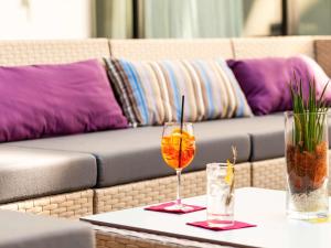 巴塞尔巴塞尔市诺富特酒店的一张桌子,上面有两杯眼镜和一张沙发