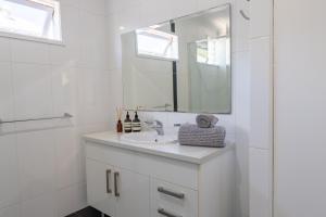 布里斯班The Hawthorne的白色的浴室设有水槽和镜子