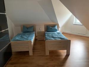 埃森Schöne Ferienwohnung im Dachgeschoss的小房间设有两张带蓝色枕头的床