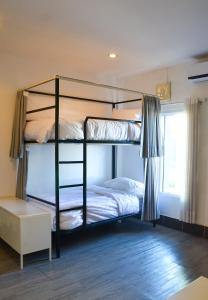 万象HideSeek Hostel Vientiane Thai embassy的一间卧室设有两张双层床和一扇窗户。