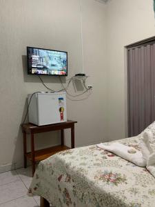 卡罗莱纳Pousada Vidal的卧室配有一张床,墙上配有电视。