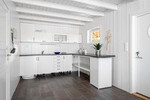 斯塔万格RoaldsPiren Stavanger的白色的厨房配有白色的橱柜和柜台。