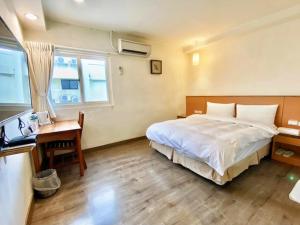 新竹老爷旅社的酒店客房配有一张床、一张书桌和一张书桌。
