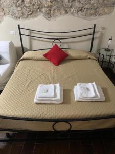 蒙泰罗通多库佩拉住宿加早餐旅馆的床上有两条毛巾和红色枕头