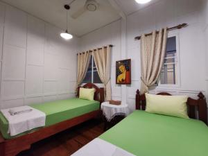 曼谷TAVEE Guesthouse的客房设有两张床和窗户。