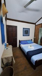 沙湾拿吉Sala Thongyon - Guest House的酒店客房设有两张床和一张桌子。