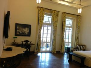 加尔各答哈灵顿住宿加早餐旅馆的客房设有床、桌子和窗户。